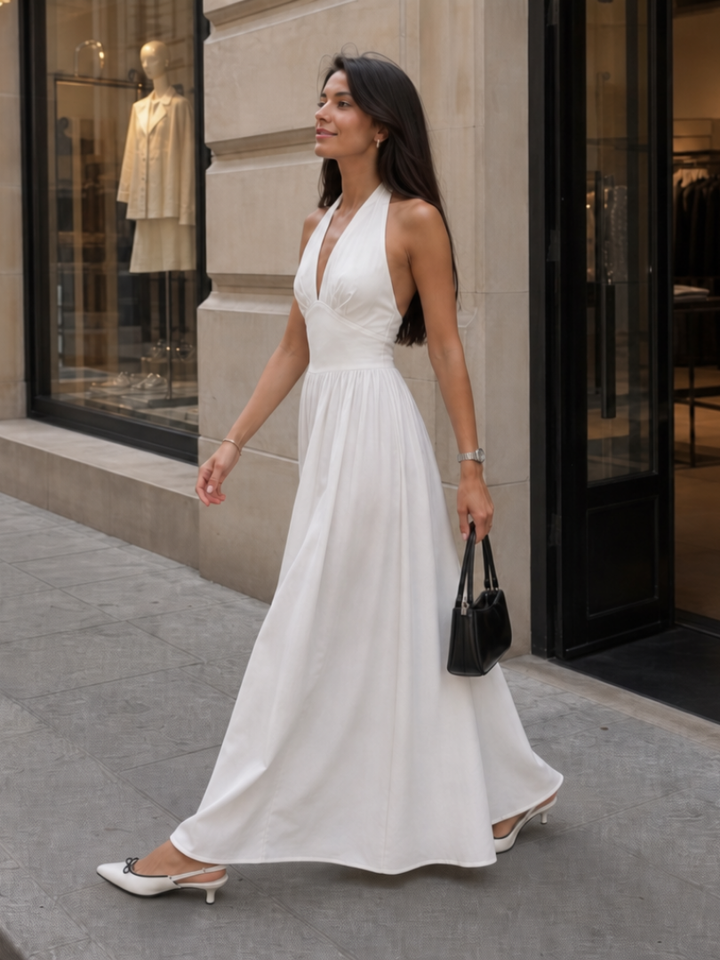 Versatile women's apparel: a sleeveless halter neck fitted midi dress, essential for summer elegance.