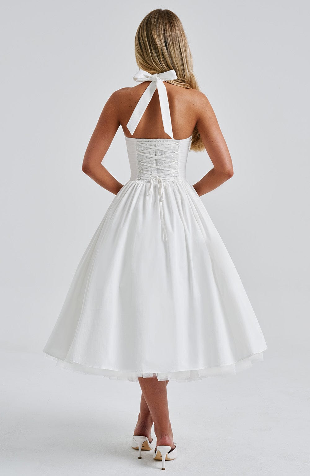 Close-up of the smocked bodice on a chic women's halter midi dress, showing textured detail.