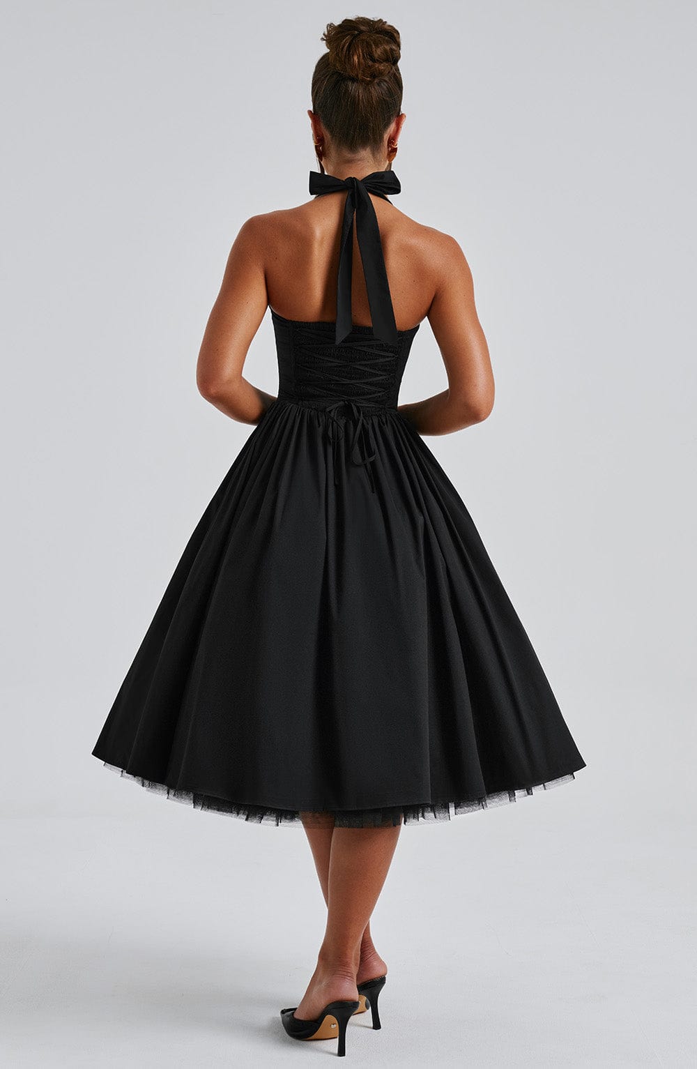 Woman wearing an elegant halter pleated midi dress, a chic summer party dress for any occasion.