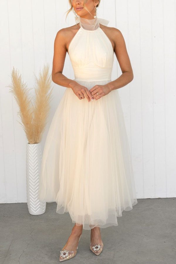 Sleeveless formal halterneck maxi dress for women, suitable as a wedding guest or elegant party gown.