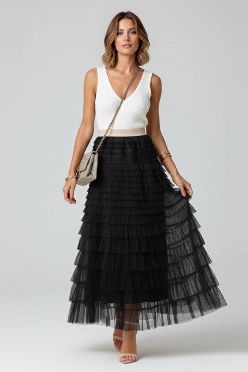 Elegant women's high-waist flowing midi skirt with beautiful tiers, perfect for a chic and versatile spring look.