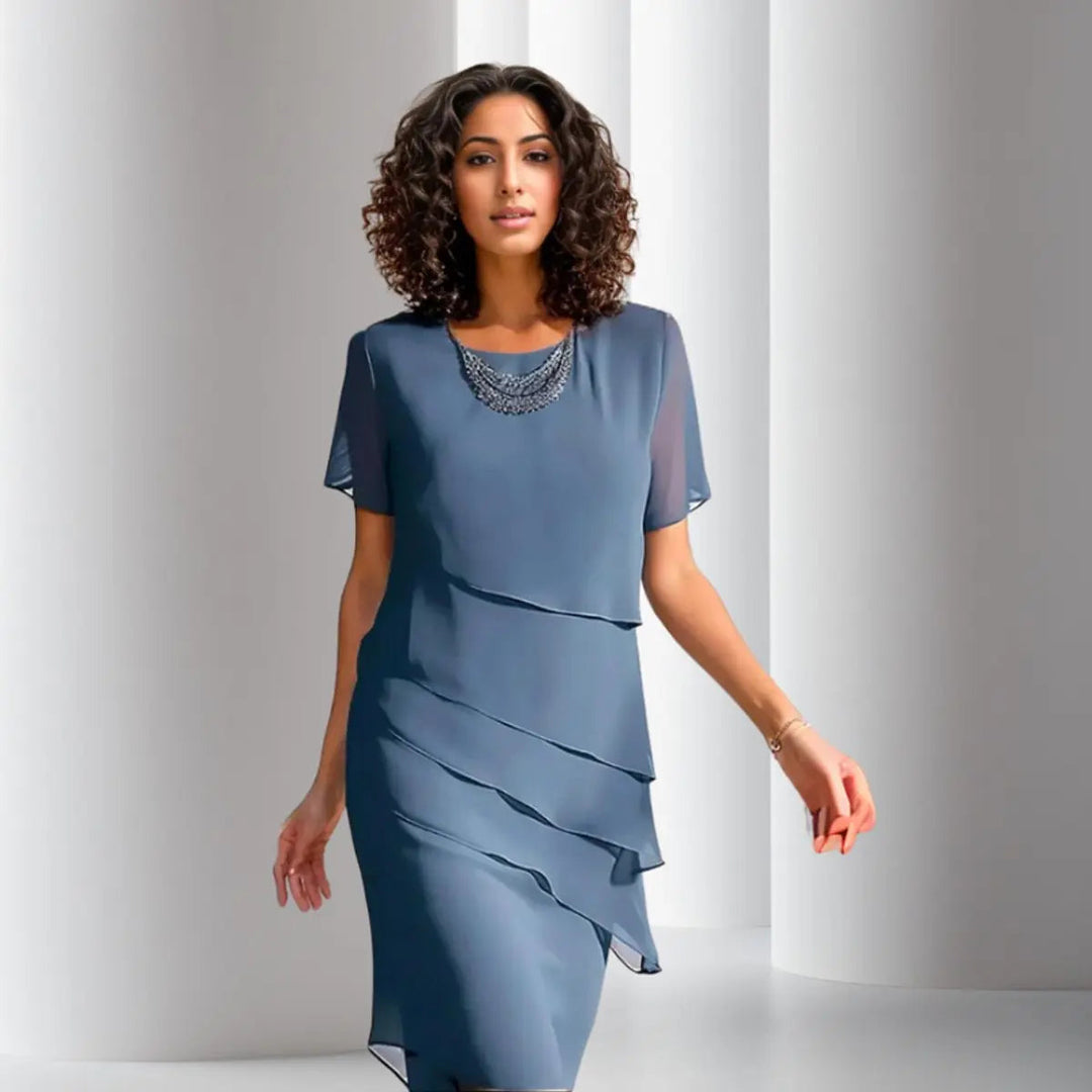 Woman wearing a stylish tiered short sleeve midi dress, perfect for a cocktail party or event.