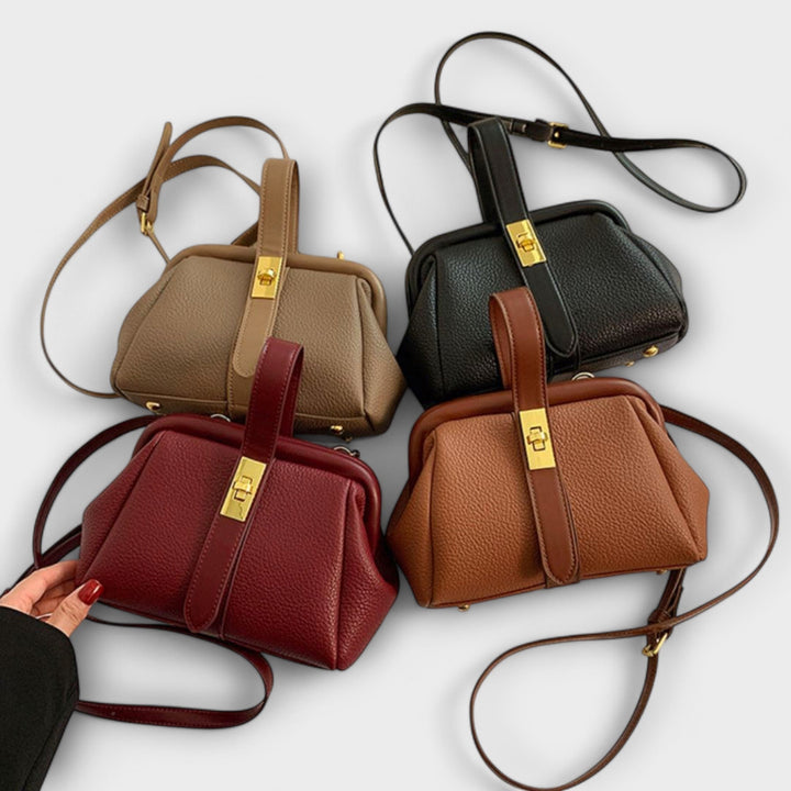 Elegant women's black leather mini crossbody bag, complete with a gleaming gold turn lock.