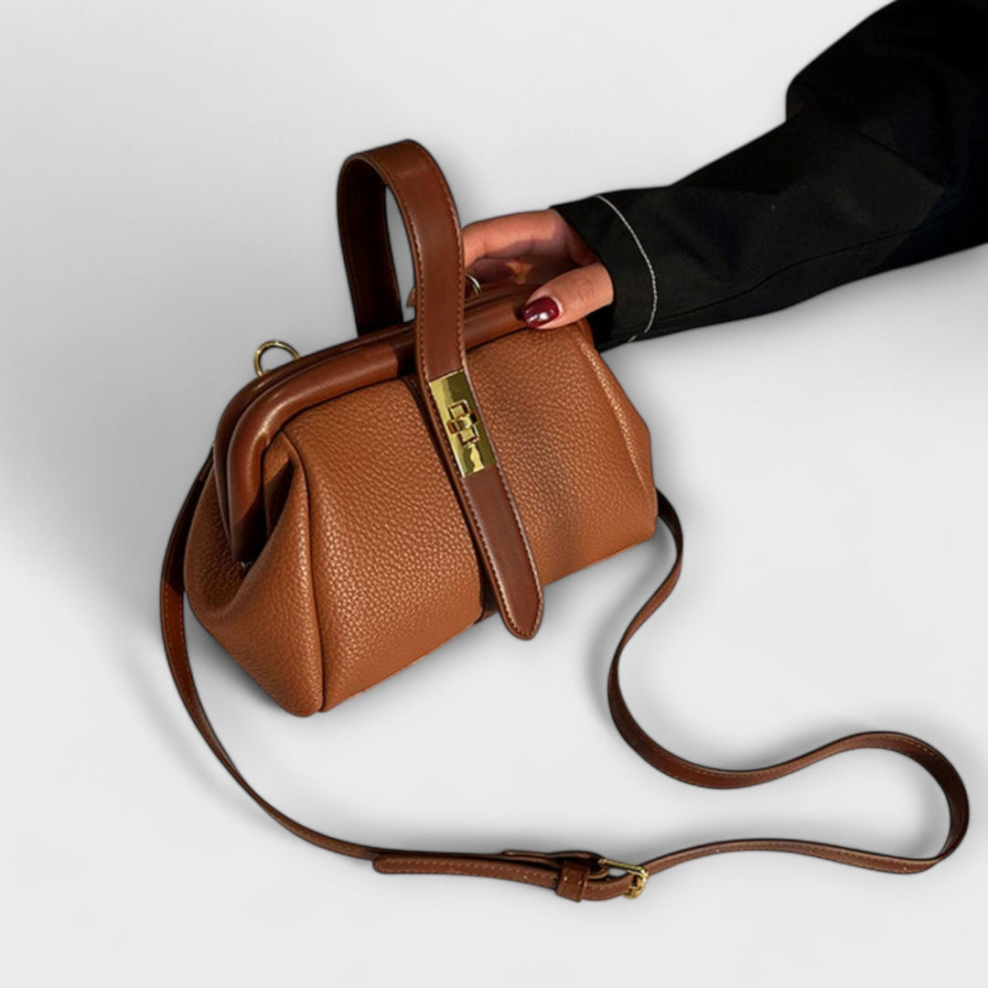 Close-up of the sophisticated turn lock closure on a vibrant red elegant leather mini handbag.