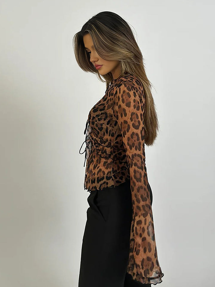 Fashionable women's animal print sheer long sleeve top with ruffle tie detail and elegant v-neck.