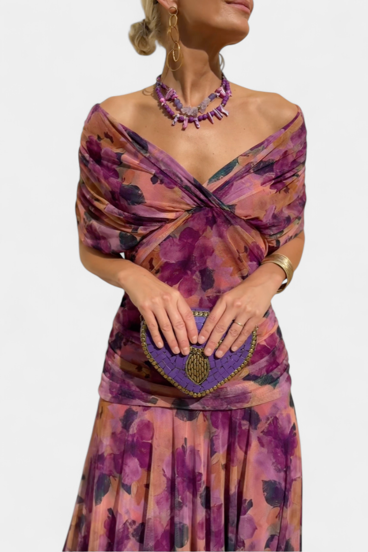 Back view of an elegant women's long floral maxi dress, showcasing its flowing fabric and print.