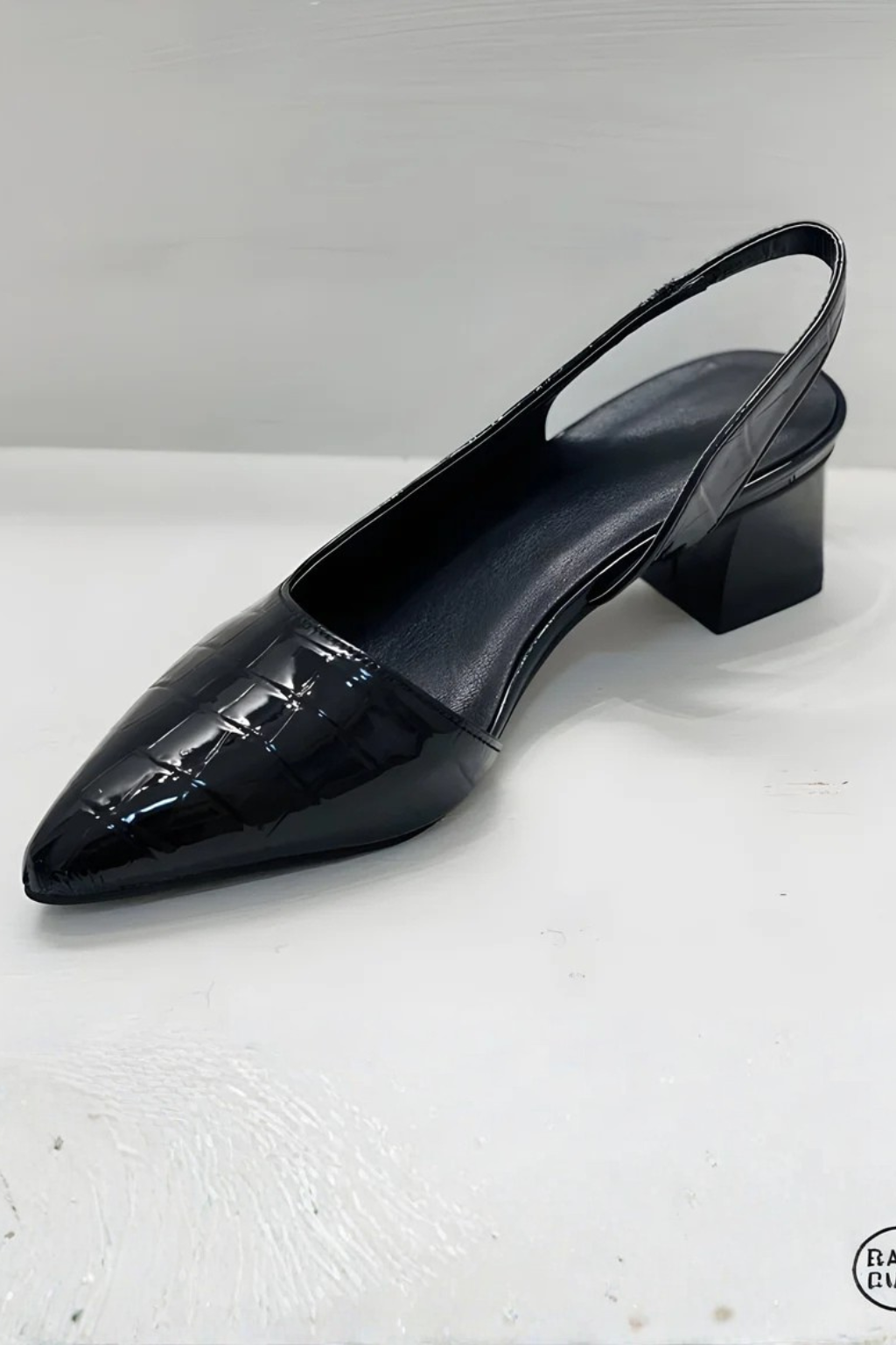 Classic black women's slingback pumps with a sleek pointed toe and low heel, ideal for dressy occasions.