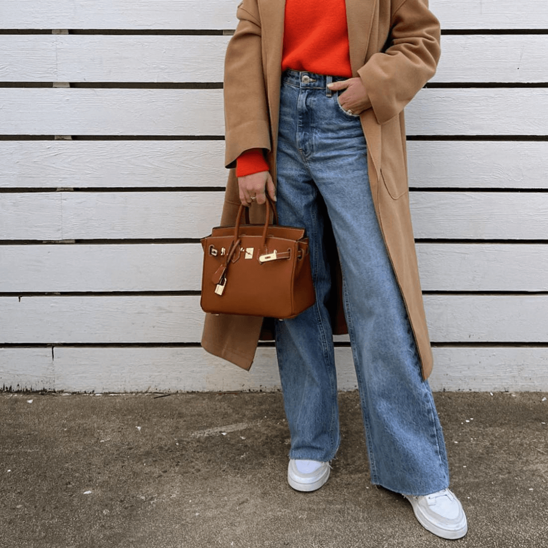 Woman wearing versatile luxury shoulder bag, a trendy fashion accessory for her outfit.