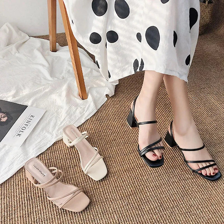 Close-up of women's dress sandals: intricate multi-strap design, sturdy block heel, and sleek square toe.