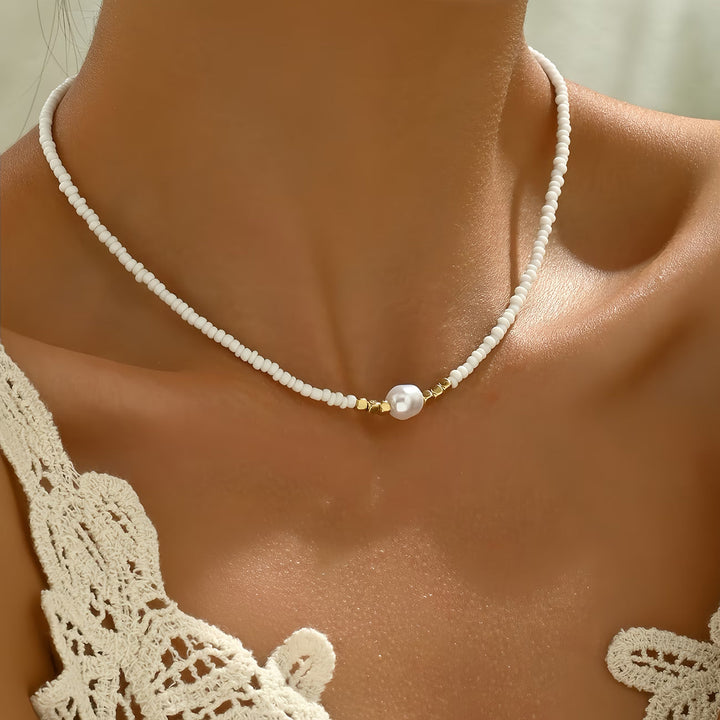 Close-up of an elegant women's pearl and turquoise necklace, showcasing white pearls and blue stones.