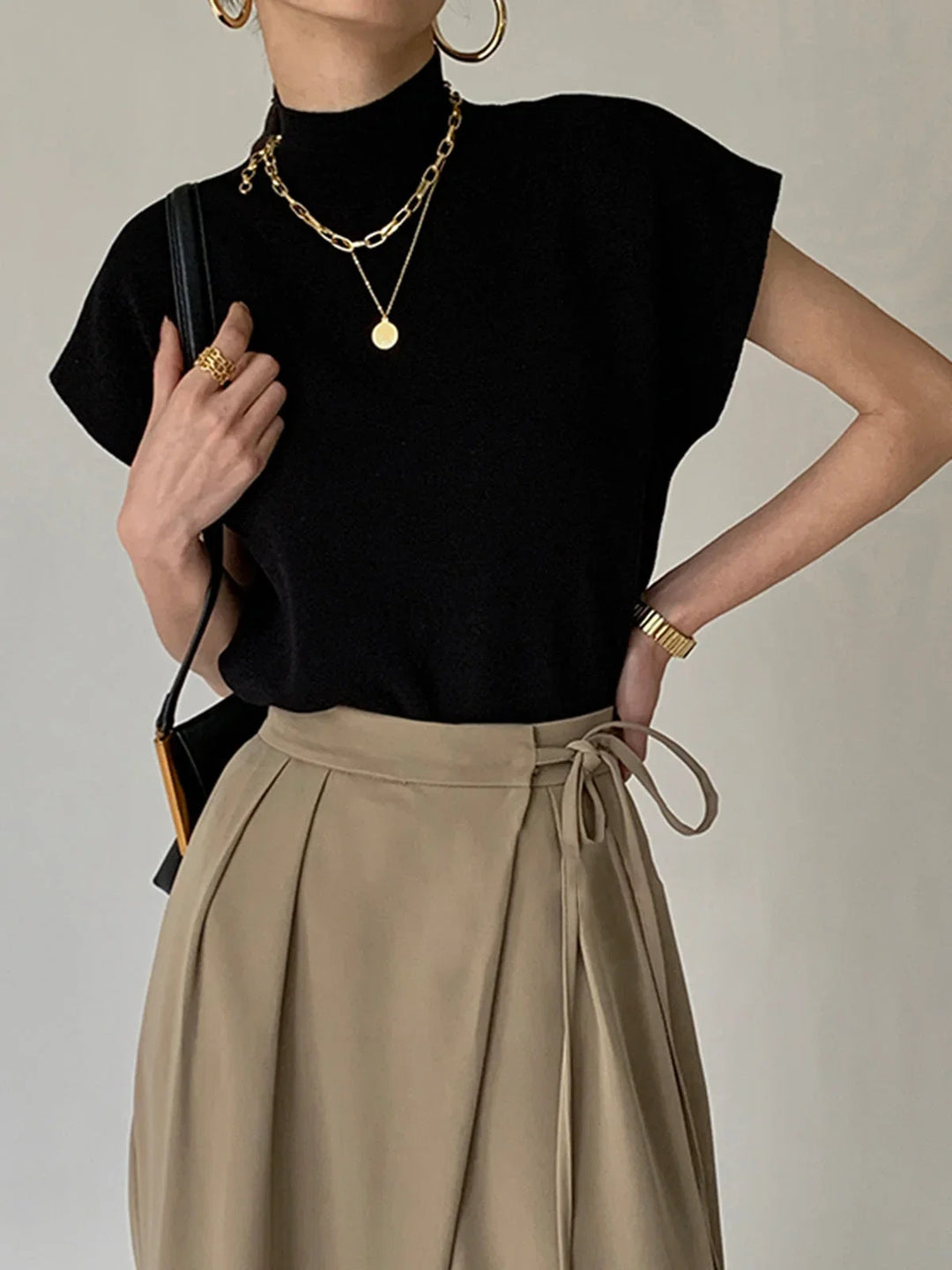 Elegant women's padded-shoulder mock-neck top with chic cap sleeves, perfect for smart casual wear.
