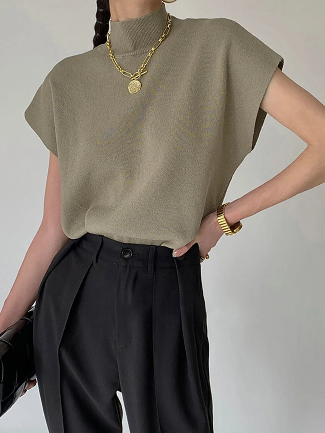 Solid women's mock neck top with sophisticated padded shoulders and trendy cap sleeves.