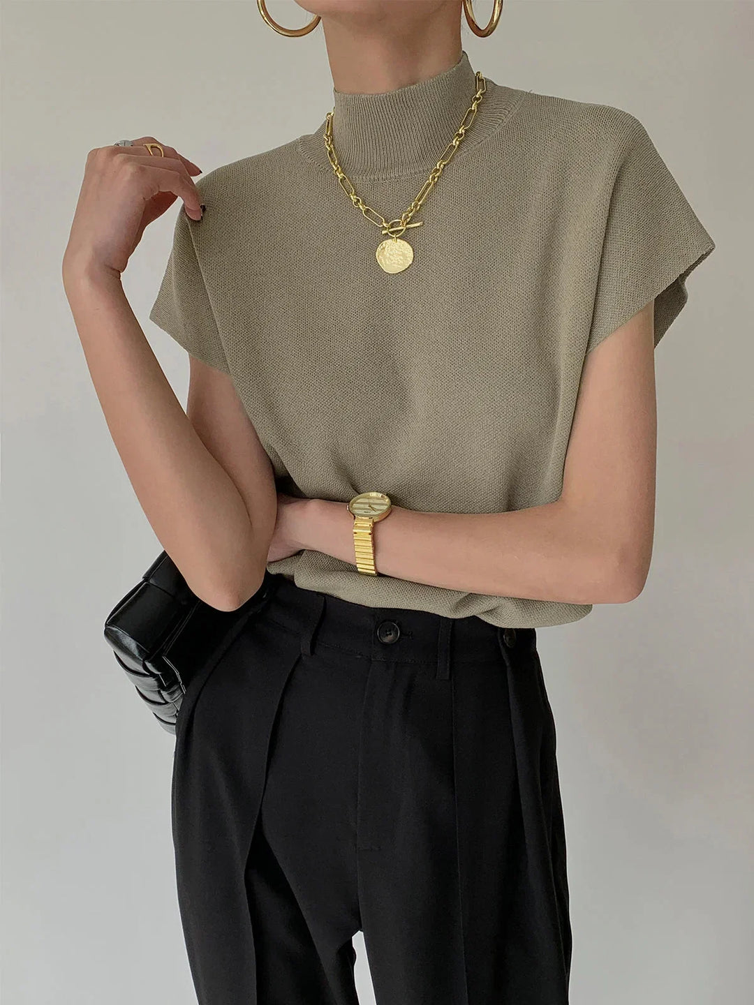 Chic women's mock-neck sweater with structured padded shoulders and stylish cap sleeves.