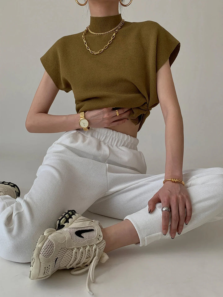 Structured women's padded-shoulder top with a chic mock neck and short cap sleeves.