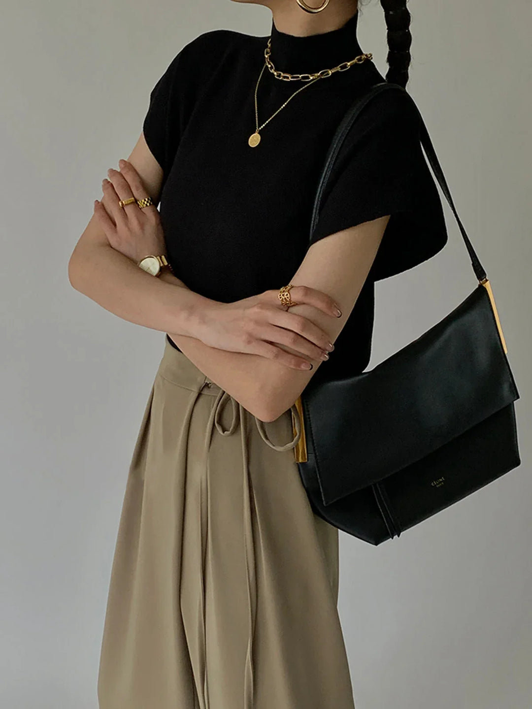 Women's elegant cap sleeve mock-neck top with subtle padded shoulders for a refined silhouette.