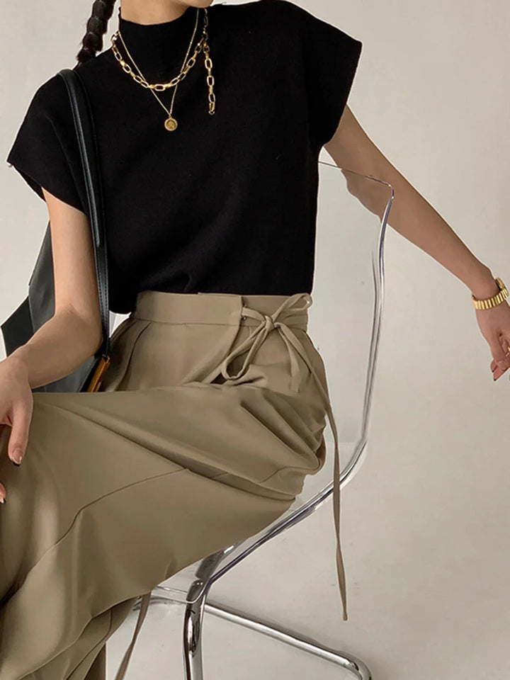 Chic solid color women's top with a high mock neck, padded shoulders, and short cap sleeves.