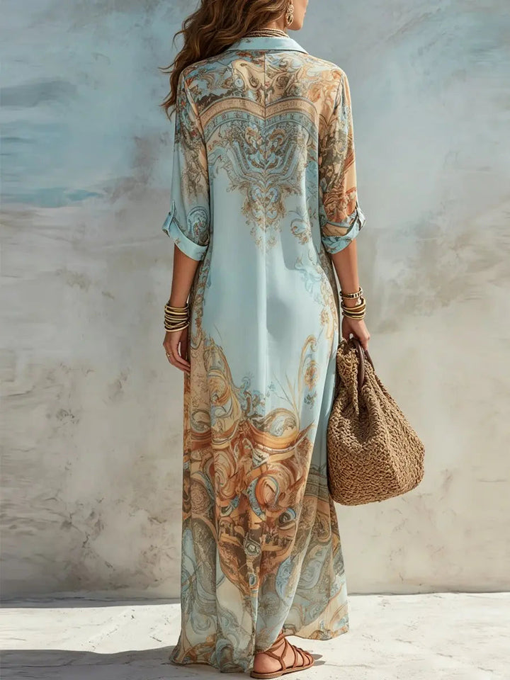 Long-sleeved women's button-through maxi shirt dress featuring a vibrant paisley print. Elegant flowy summer style.