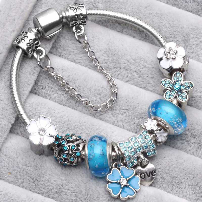 Close-up of a detailed peach blossom charm bracelet. An elegant women's wrist accessory, perfect for fashion-forward styling.