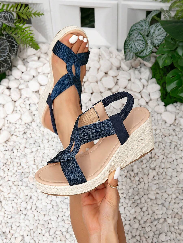 Comfortable women's wedge sandals with adjustable criss-cross straps and platform sole for elegant wear.