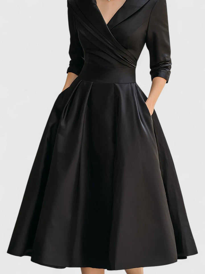 Flared women's elegant midi dress. Features a flattering wrap top and a beautifully pleated skirt for a formal look.