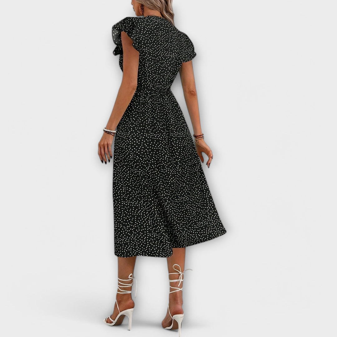Close-up of soft fabric on an elegant women's polka dot A-line midi dress, perfect for summer.