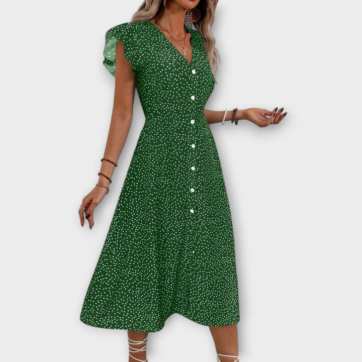 Woman models elegant polka dot A-line V-neck midi dress, ideal for spring & summer occasions.