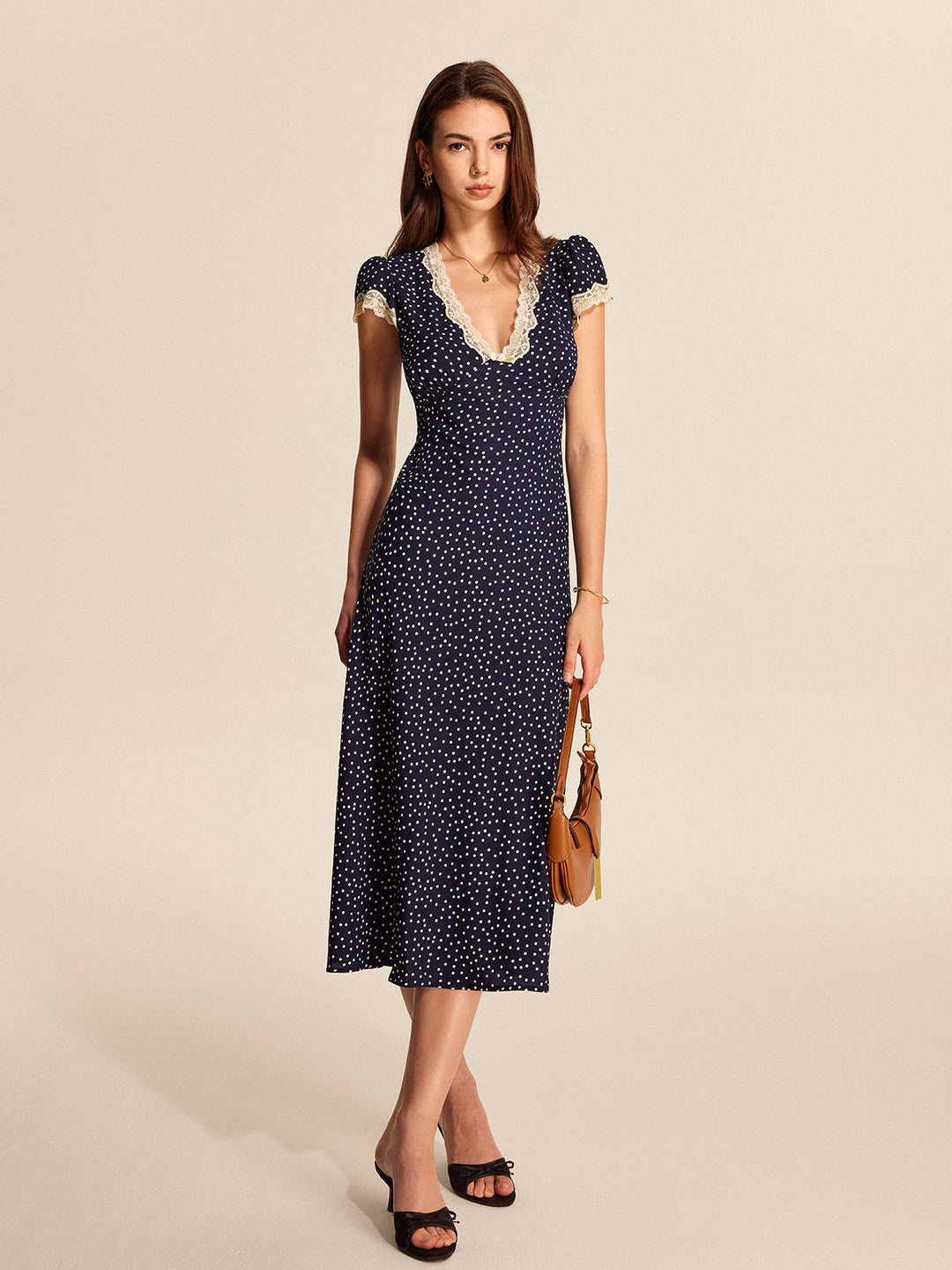 Feminine polka dot midi dress for women, featuring elegant lace & trendy puff sleeves. Ideal for day or evening wear.