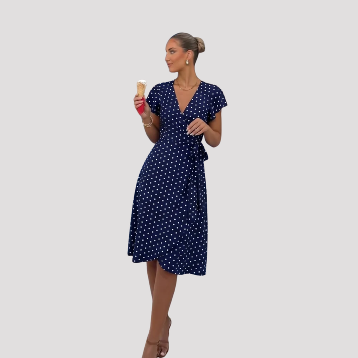 Stylish polka dot wrap midi dress for women. Features V-neck, flutter sleeves & tie waist, ideal for casual or party wear.