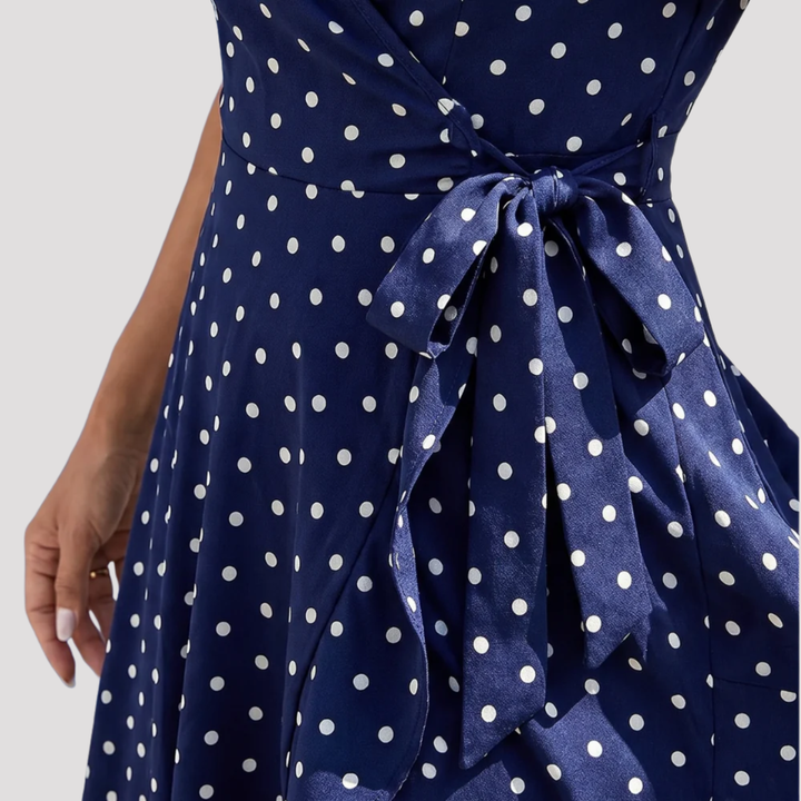 Chic women's polka dot midi wrap dress. V-neck, flutter sleeves, tie-waist. Versatile for casual, party, or elegant wear.