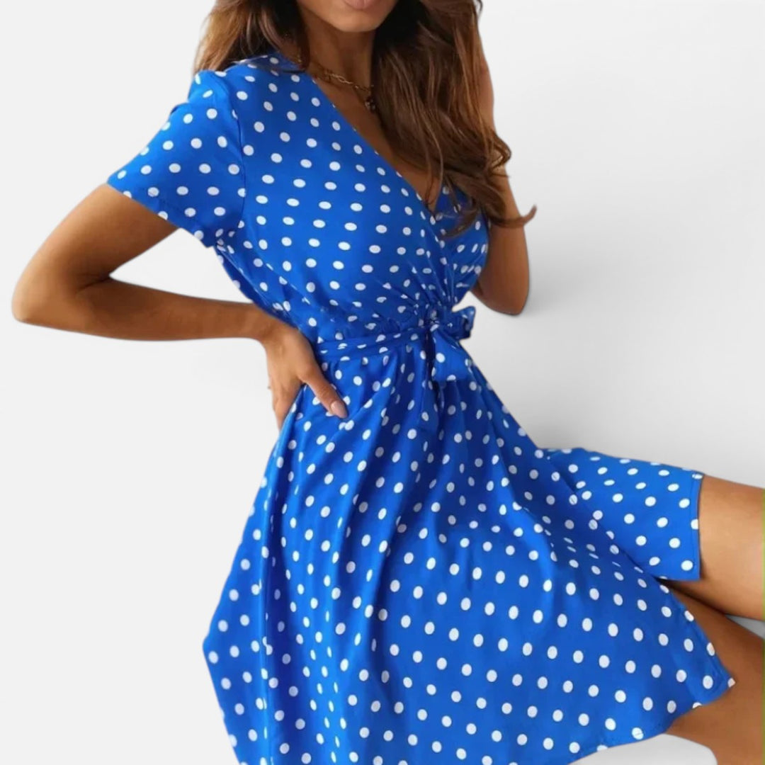 Women's chic polka dot mini wrap dress. Short sleeve design, ideal for versatile day elegance.