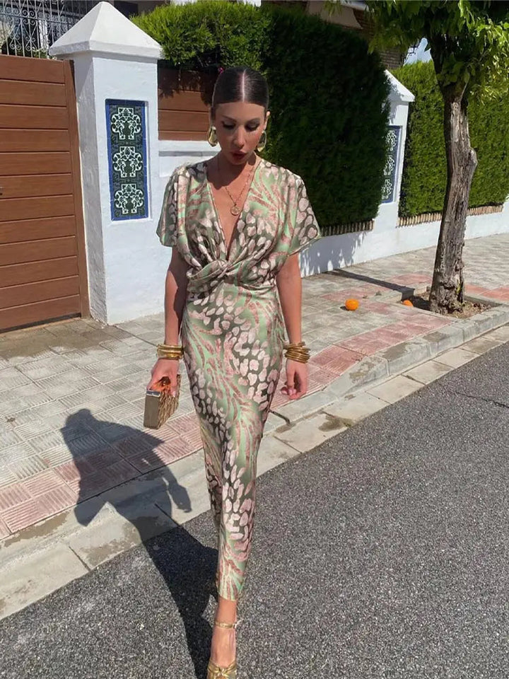 Fluid feminine printed midi dress with a stylish twist-front detail, ideal for summer parties.