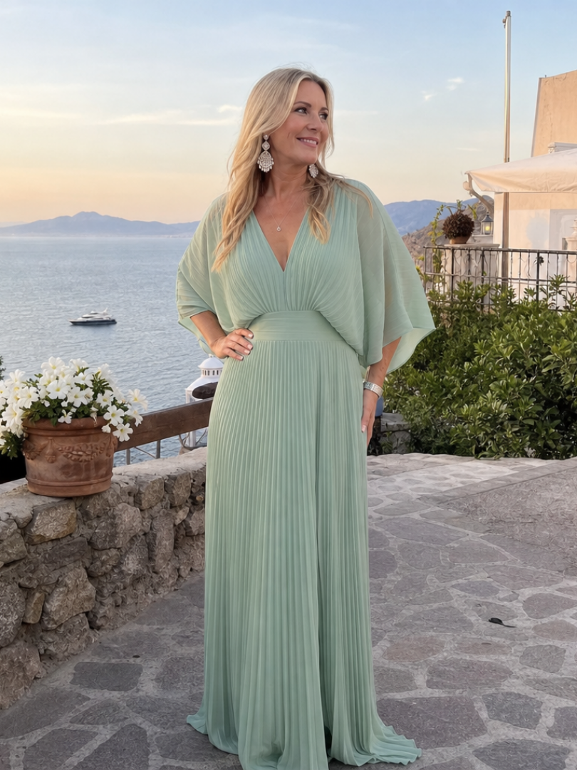 Stylish green women's pleated maxi dress, V-neck, long sleeves. An elegant evening or formal party dress.