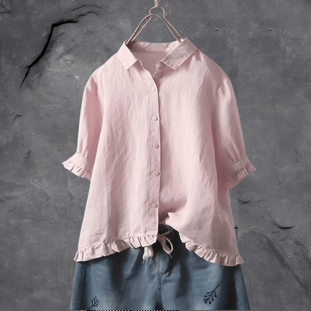 Fashionable pink women's collared blouse with a delicate ruffled hem and short sleeves. A comfortable and elegant top.