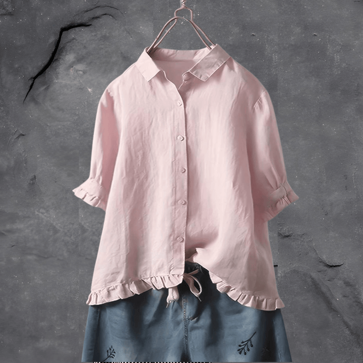 Fashionable pink women's collared blouse with a delicate ruffled hem and short sleeves. A comfortable and elegant top.