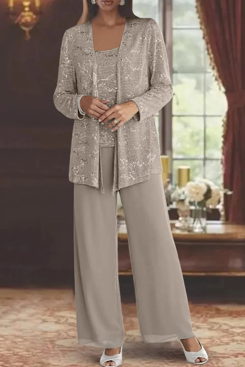 Woman models elegant sequin lace jacket & wide leg trouser suit for special occasion.