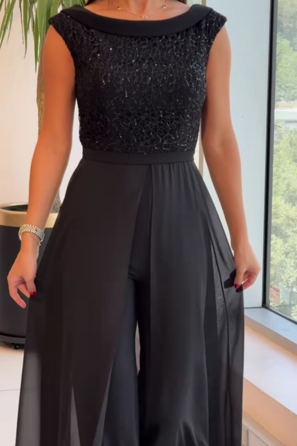 Women's formal sleeveless jumpsuit with sequin bodice overlay. Chic black evening wear, ideal for parties.
