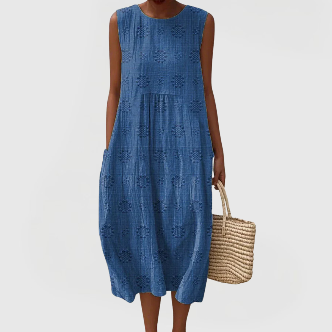 Flowy women's sleeveless dress with floral embroidery and practical pockets, ideal for casual summer style.