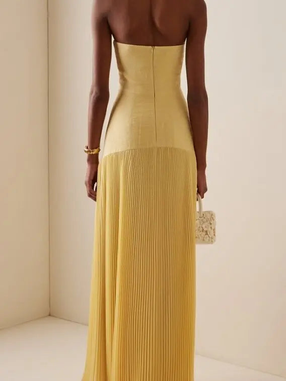 Stylish women's strapless maxi dress featuring elegant pleats. Formal evening gown for any special event.