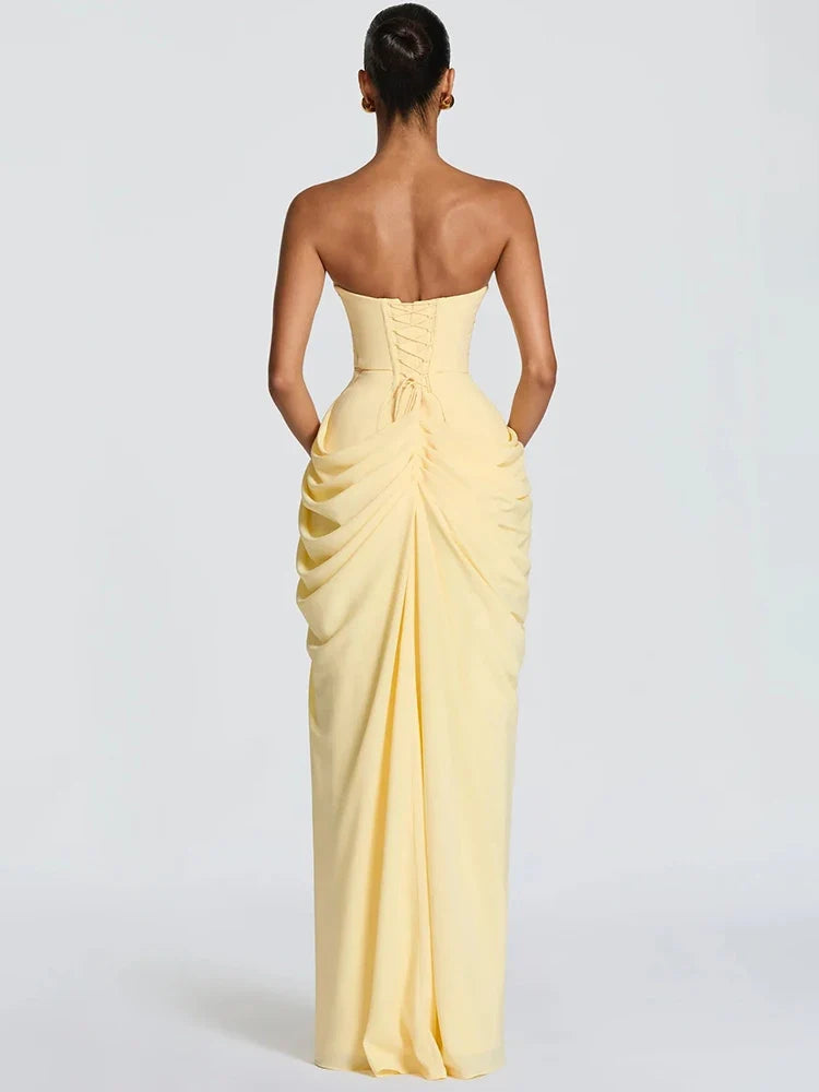 Close-up of a women's elegant strapless maxi dress with intricate ruching and a dramatic high slit detail.