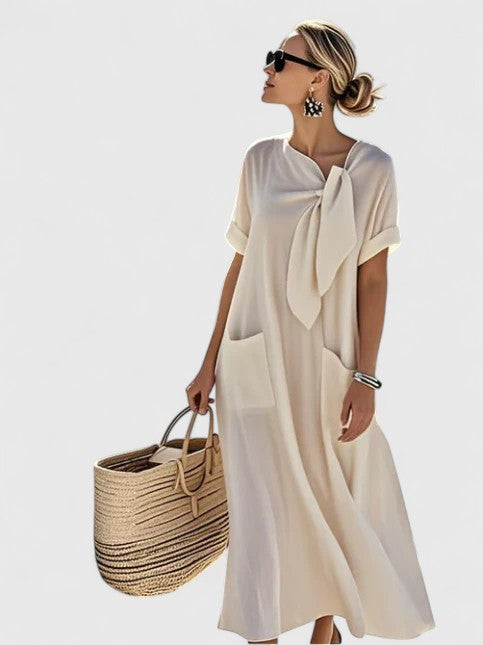 Flowy women's summer midi dress, comfortable with practical pockets. Versatile for casual or vacation style.