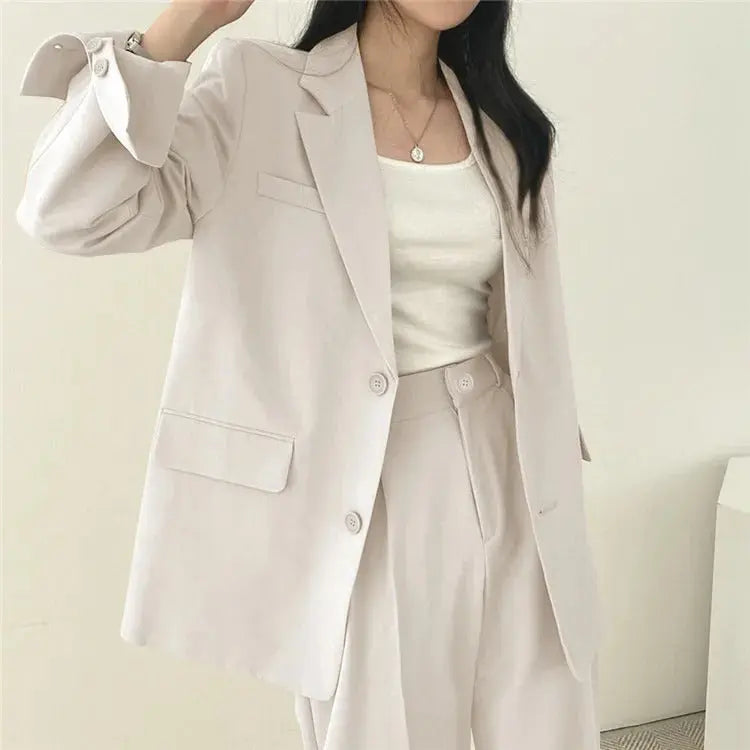 Professional women's tailored blazer and relaxed trousers, an essential two-piece office outfit.