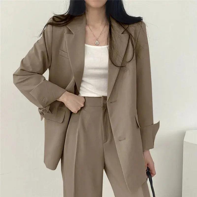 Tailored women's blazer set featuring a professional jacket and relaxed fit trousers. Versatile style.