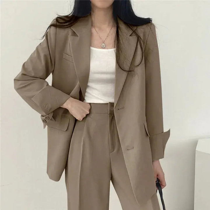 Tailored women's blazer set featuring a professional jacket and relaxed fit trousers. Versatile style.