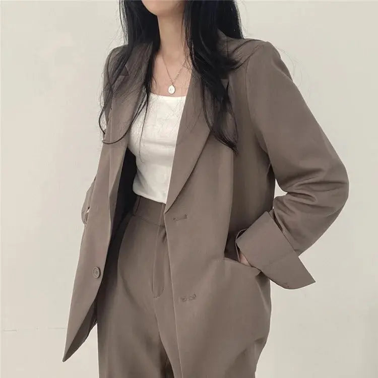 Elegant women's trouser suit with a tailored blazer and relaxed fit pants for business or formal events.