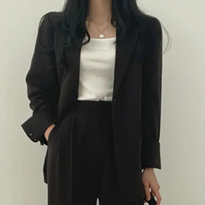 Women's versatile professional outfit: tailored blazer and relaxed fit trousers, perfect for office or formal.