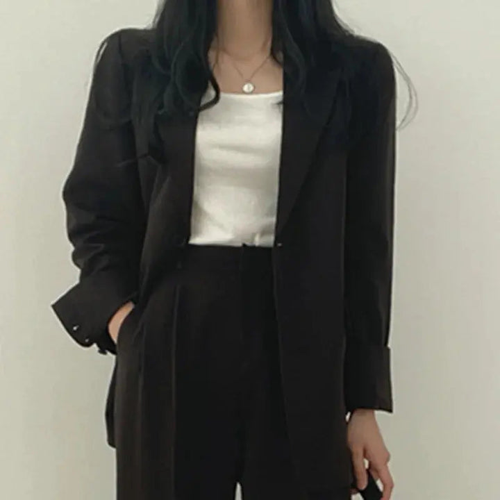 Women's versatile professional outfit: tailored blazer and relaxed fit trousers, perfect for office or formal.