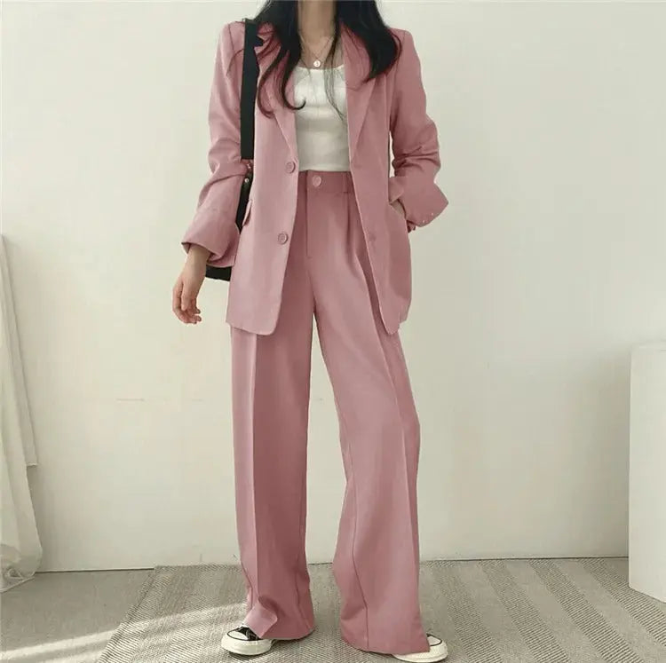 Stylish women's formal attire featuring an elegant blazer and relaxed fit trousers. Two-piece set.