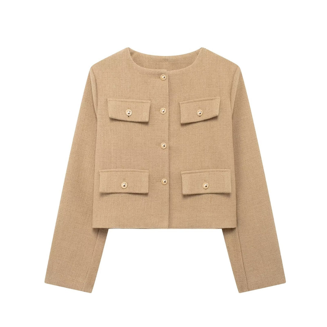 Woman wearing an elegant textured cropped button-up jacket, posing stylishly for fall.