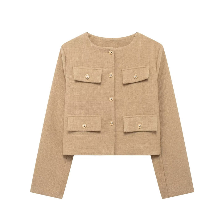 Woman wearing an elegant textured cropped button-up jacket, posing stylishly for fall.