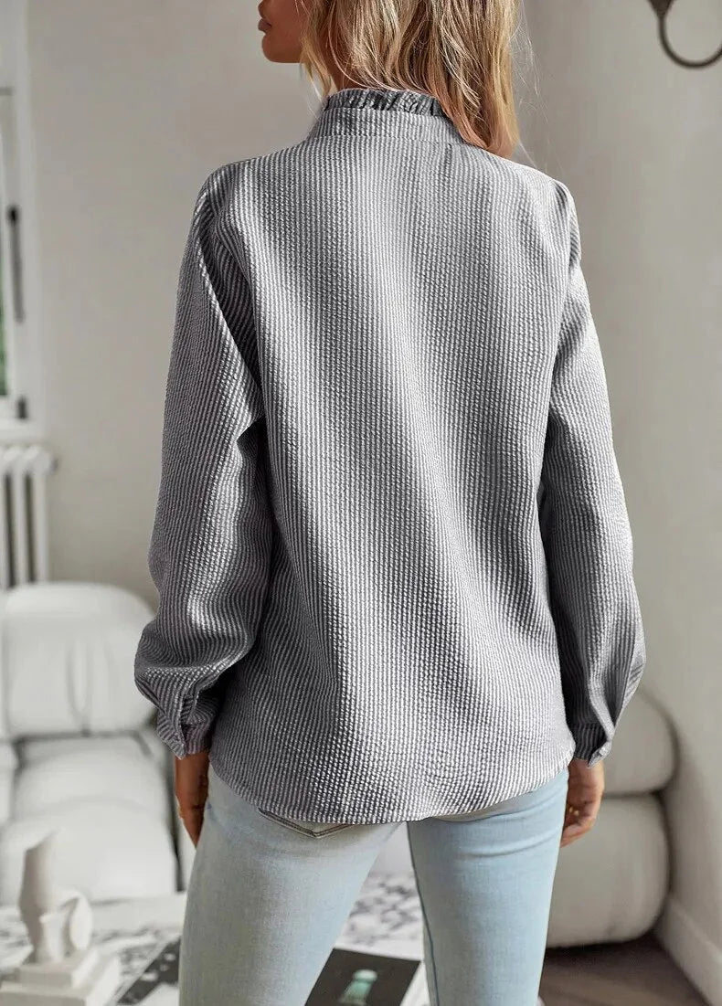 Stylish women's elegant blouse with textured stripes, a beautiful ruffled collar, & long sleeves for modern fashion.